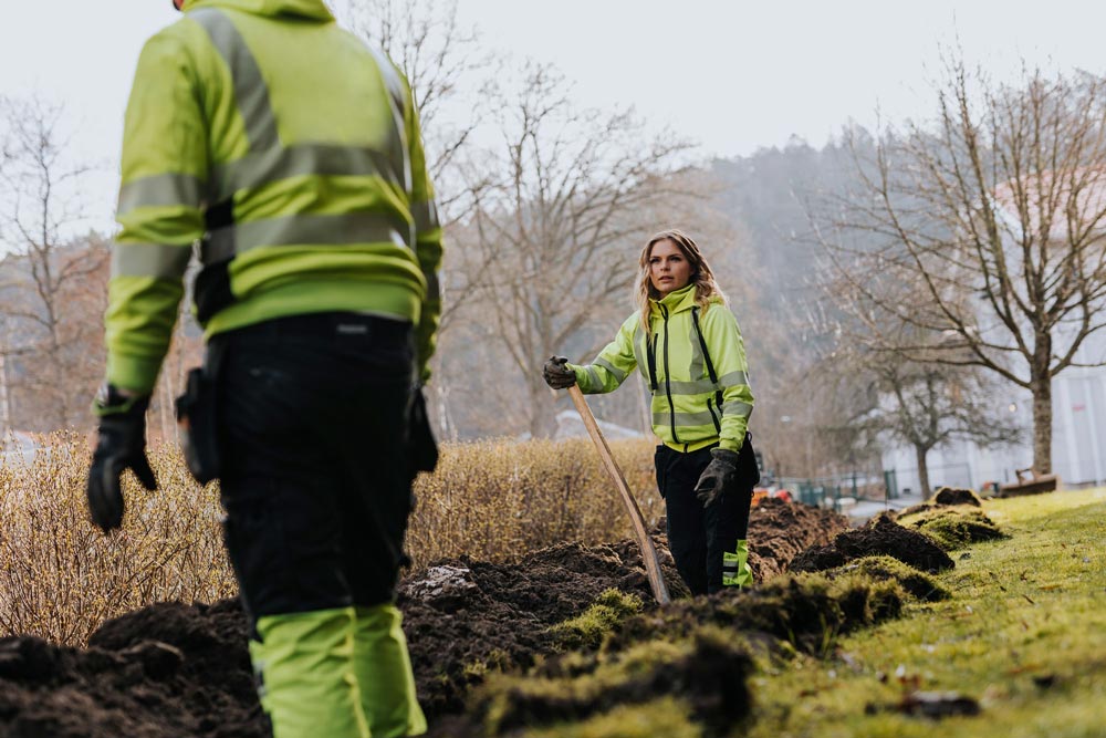 Kvinna och man som arbetar i gula kläder